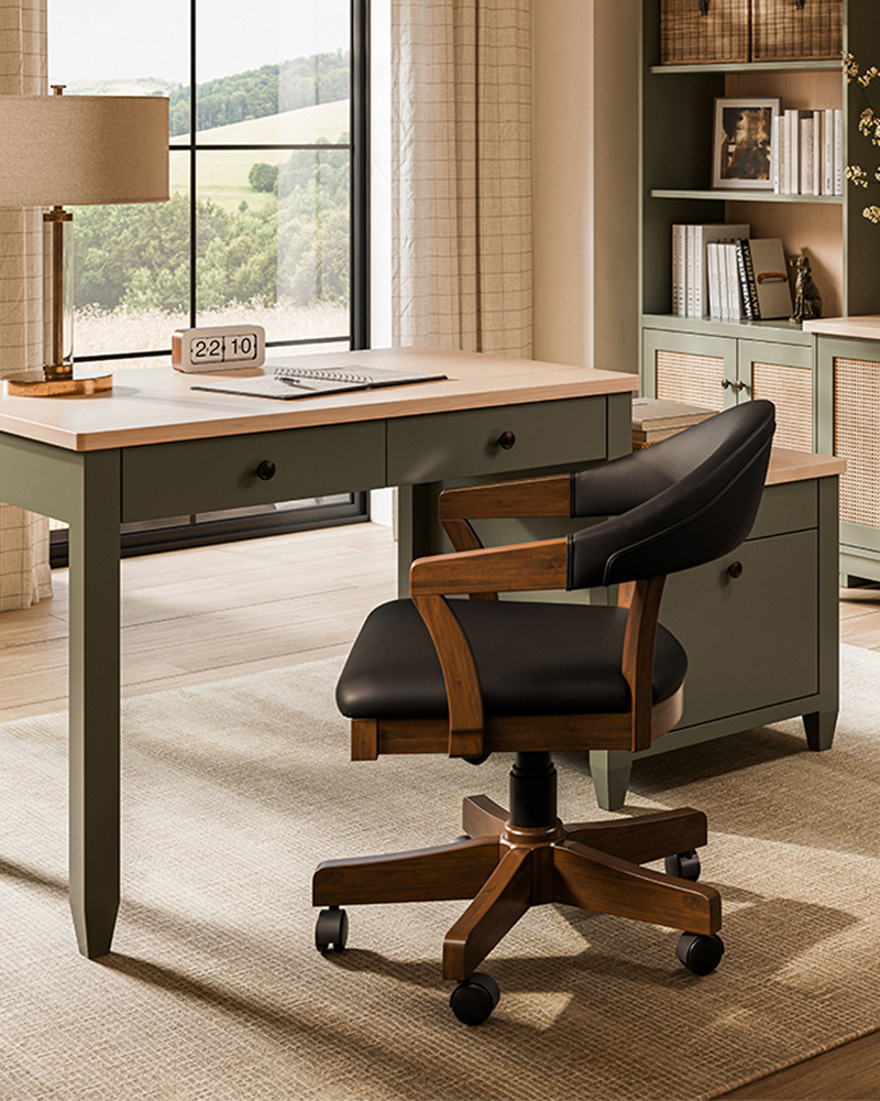 Green solid wood home office desk with black leather swivel chair and bookcase