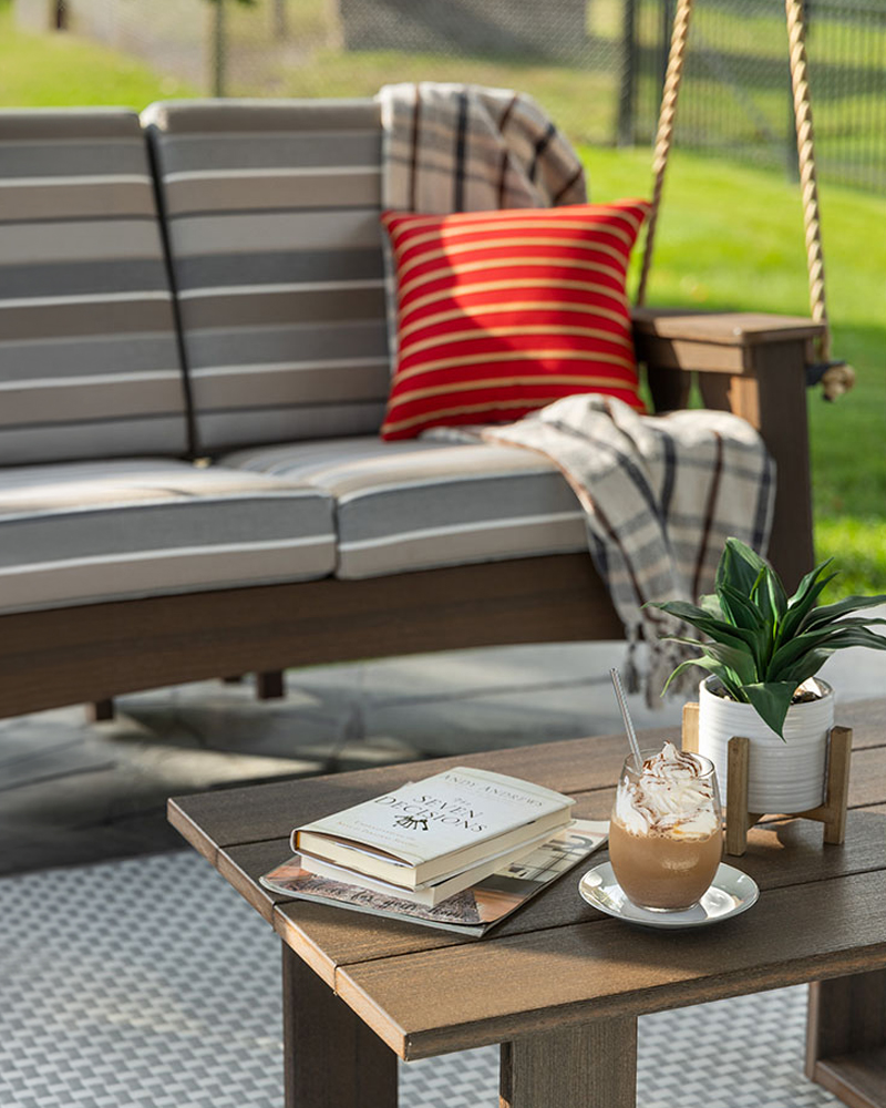 Outdoor poly porch swing furniture with striped cushions and patio coffee table