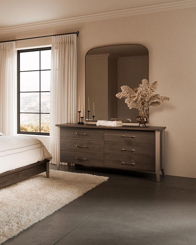 Solid wood bedroom dresser furniture with large mirror in a warm neutral room.